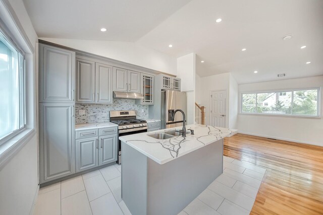 48 Hillside Ave, Patchogue, NY 11772 - kitchen with appliances with stainless steel finishes, vaulted ceiling, under cabinet range hood, gray cabinetry, and a sink