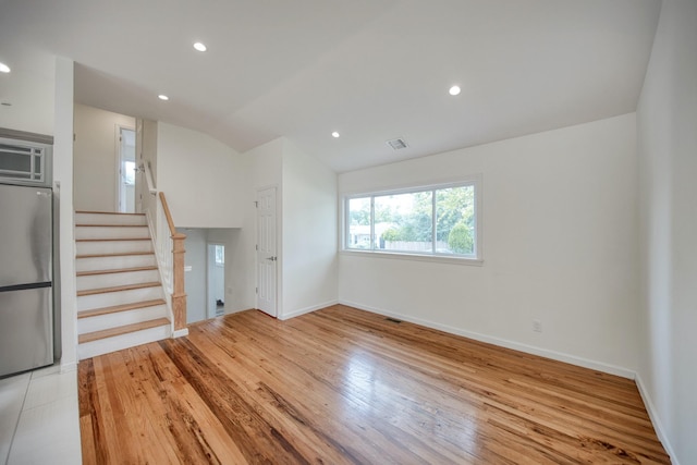 48 Hillside Ave, Patchogue, NY 11772 - unfurnished living room with vaulted ceiling, light wood-style floors, baseboards, stairs, and recessed lighting