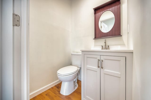 48 Hillside Ave, Patchogue, NY 11772 - bathroom featuring toilet, wood finished floors, vanity, and baseboards
