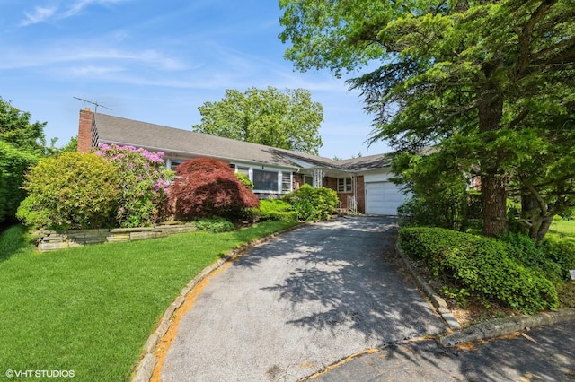 7 Ivy Ln, Lawrence, NY 11559 - single story home with an attached garage, asphalt driveway, a chimney, a front yard, and brick siding