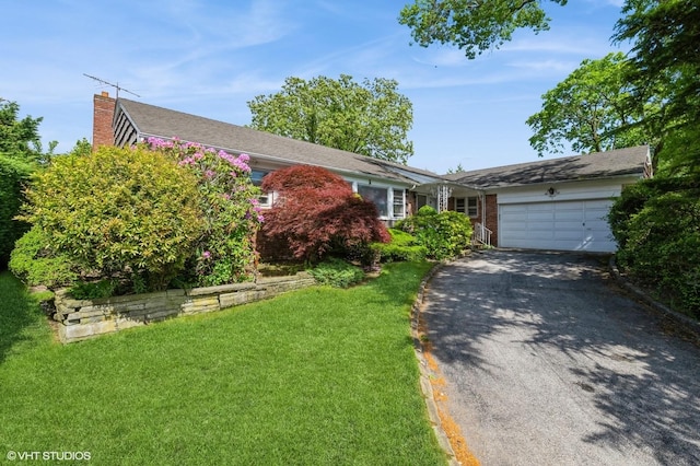 7 Ivy Ln, Lawrence, NY 11559 - view of front of house featuring driveway, an attached garage, a chimney, a front yard, and brick siding