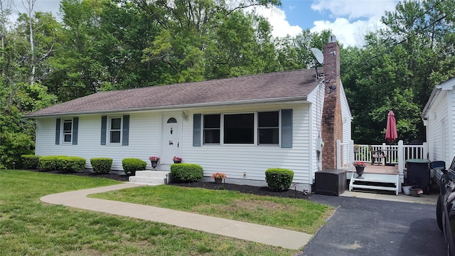 56 Church St, Wallkill, NY 12589 - view of front of property with a front lawn, a chimney, a deck, and central AC