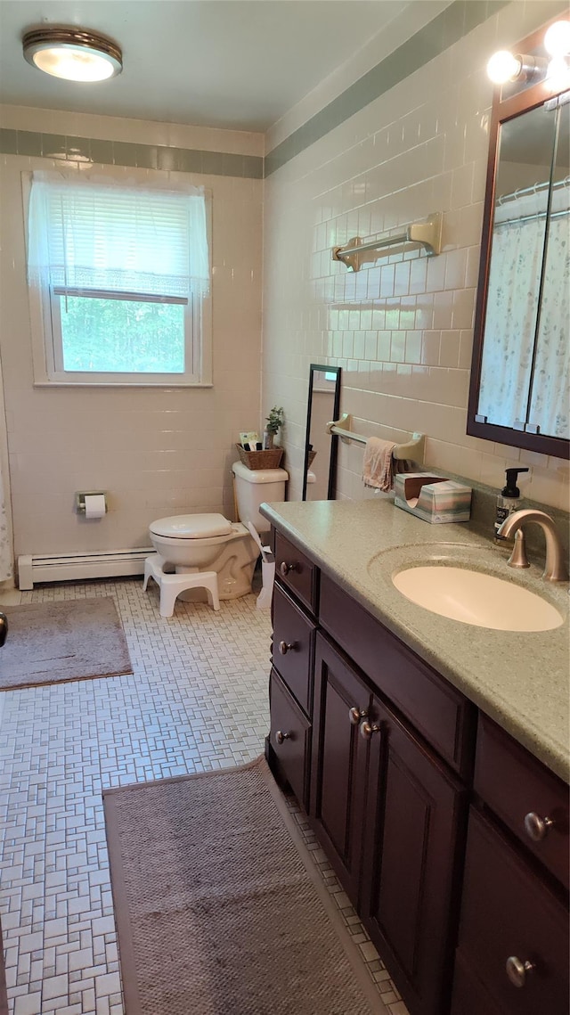 56 Church St, Wallkill, NY 12589 - full bathroom featuring a baseboard radiator, toilet, vanity, and tile walls