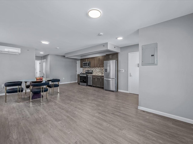 kitchen with appliances with stainless steel finishes, electric panel, dark brown cabinets, baseboards, and recessed lighting