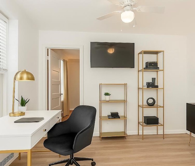 office area featuring light wood finished floors, ceiling fan, and baseboards