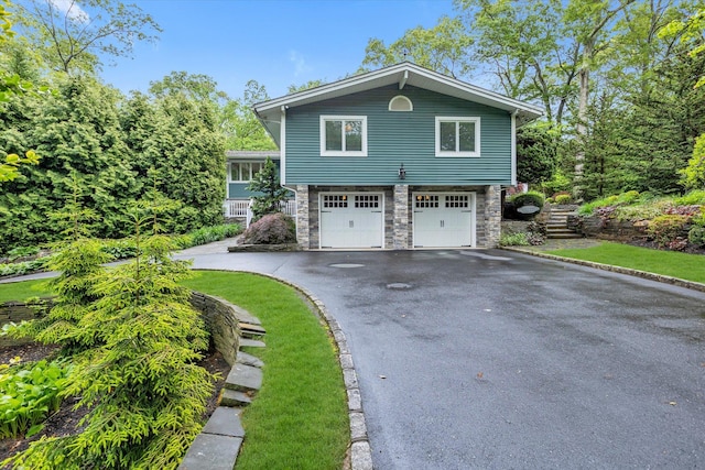 7 Tuxedo Dr, Melville, NY 11747 - view of front of house featuring stone siding, driveway, and a garage
