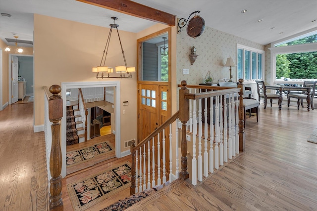 7 Tuxedo Dr, Melville, NY 11747 - staircase with wallpapered walls, wood finished floors, vaulted ceiling, and baseboards