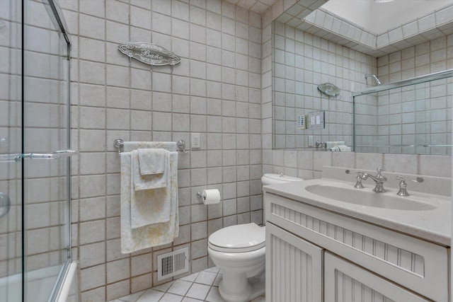 7 Tuxedo Dr, Melville, NY 11747 - full bathroom featuring tile walls, tile patterned flooring, toilet, vanity, and shower / bath combination with glass door