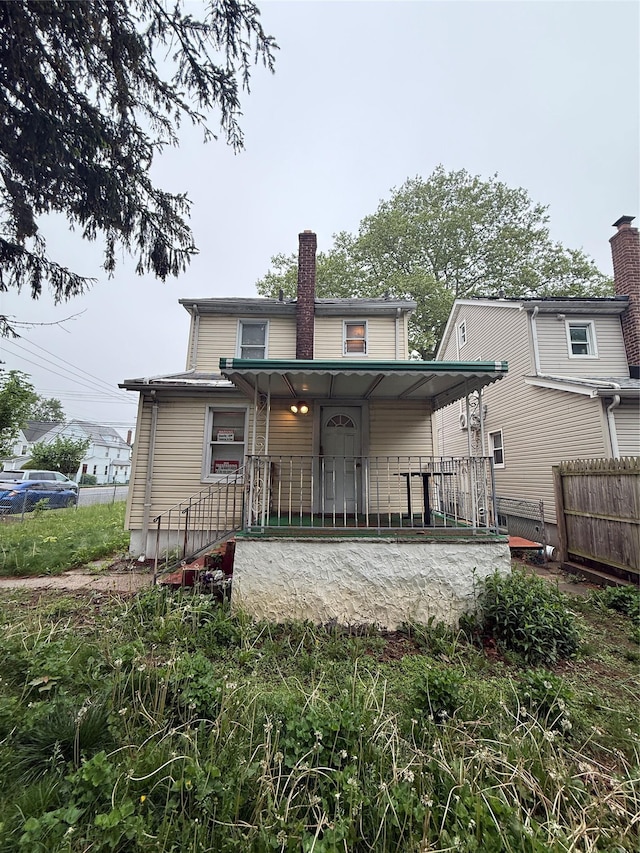 114-02 208th St, Saint Albans, NY 11411 - back of house featuring covered porch, fence, and a chimney