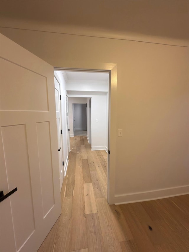 corridor featuring light wood-style floors and baseboards