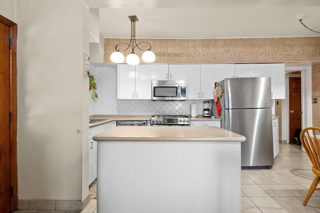 2816 215th Pl, Bayside, NY 11360 - kitchen featuring appliances with stainless steel finishes, light countertops, decorative backsplash, white cabinets, and a center island