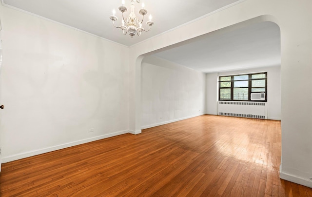 67-71 Yellowstone Blvd Unit 3-L, Forest Hills, NY 11375 - empty room featuring radiator, arched walkways, a chandelier, wood-type flooring, and crown molding