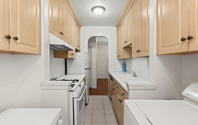 67-71 Yellowstone Blvd Unit 3-L, Forest Hills, NY 11375 - kitchen featuring washer / clothes dryer, a sink, under cabinet range hood, light brown cabinets, and white range with gas stovetop