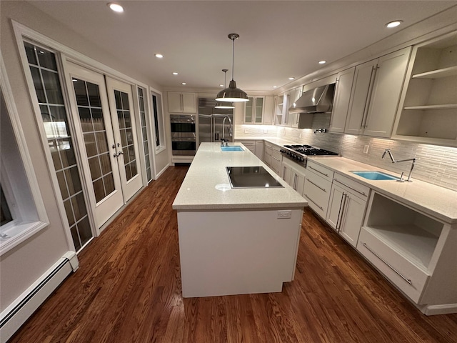 107 Norwood Ave, Northport, NY 11768 - kitchen featuring open shelves, baseboard heating, appliances with stainless steel finishes, a sink, and wall chimney range hood
