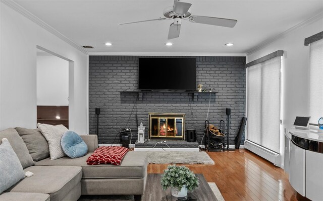 94 Stonehurst Ln, Dix Hills, NY 11746 - living room featuring baseboard heating, ornamental molding, light wood-style flooring, a brick fireplace, and ceiling fan