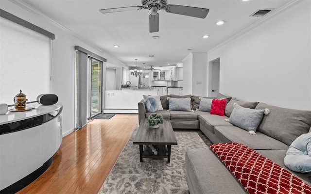 94 Stonehurst Ln, Dix Hills, NY 11746 - living area with baseboard heating, a chandelier, ornamental molding, light wood-style floors, and a ceiling fan