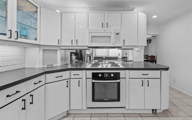 94 Stonehurst Ln, Dix Hills, NY 11746 - kitchen with white appliances, white cabinetry, dark countertops, decorative backsplash, and crown molding
