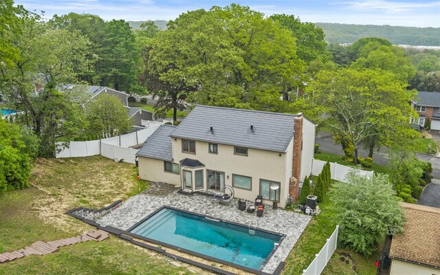 94 Stonehurst Ln, Dix Hills, NY 11746 - rear view of property featuring a fenced backyard, a chimney, and a patio area