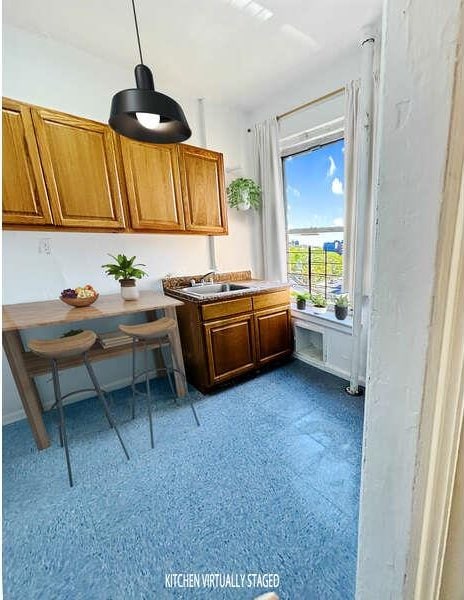 1898 Longfellow Ave Unit E4, Bronx, NY 10460 - kitchen with brown cabinetry, a sink, decorative light fixtures, and breakfast area