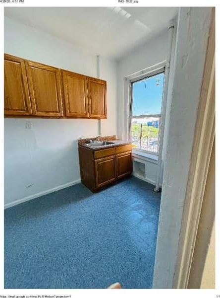 1898 Longfellow Ave Unit E4, Bronx, NY 10460 - kitchen with dark carpet, brown cabinetry, baseboards, and a sink
