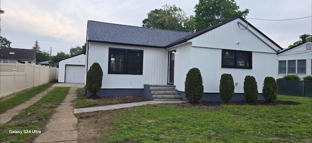 151 Boylston St, Hempstead, NY 11550 - view of front facade featuring driveway, entry steps, roof with shingles, and a detached garage