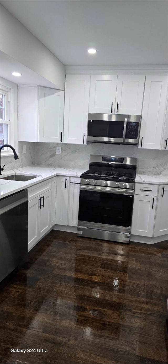151 Boylston St, Hempstead, NY 11550 - kitchen with appliances with stainless steel finishes, a sink, light stone counters, white cabinets, and recessed lighting