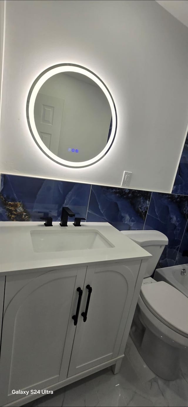 151 Boylston St, Hempstead, NY 11550 - bathroom with marble finish flooring, vanity, toilet, tile walls, and a tub to relax in
