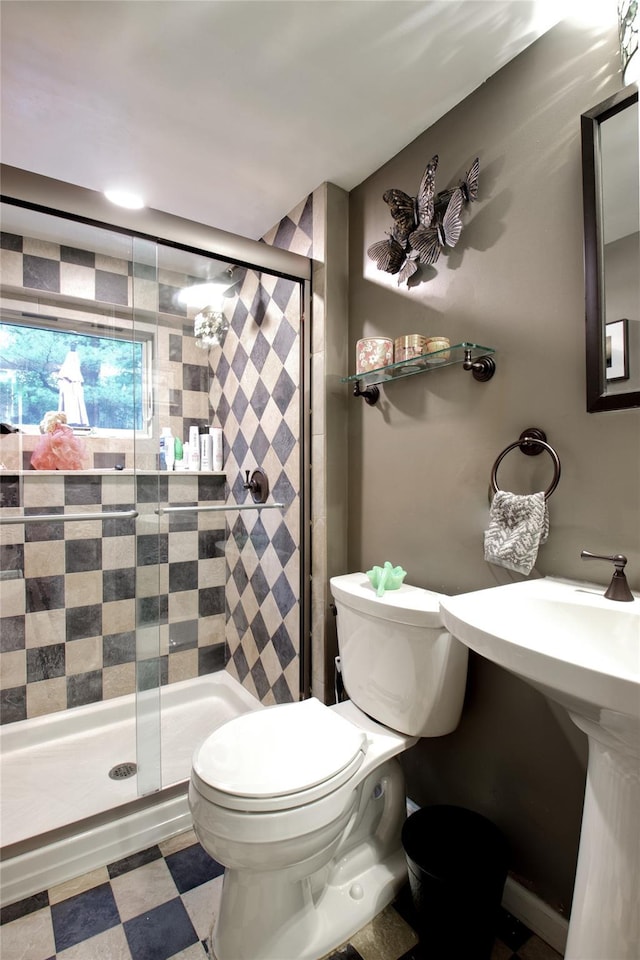 full bath featuring toilet, a shower stall, and tile patterned floors