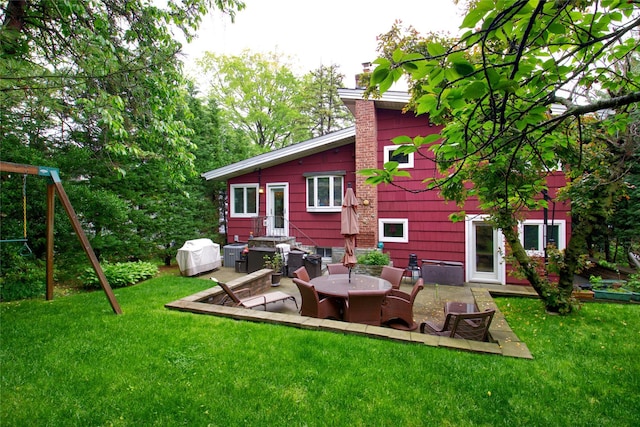 back of house with a chimney, a patio, and a yard