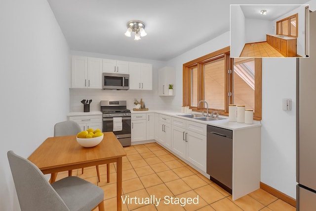 3893 Rte 82, Millbrook, NY 12545 - kitchen featuring appliances with stainless steel finishes, a sink, light tile patterned floors, tasteful backsplash, and white cabinetry