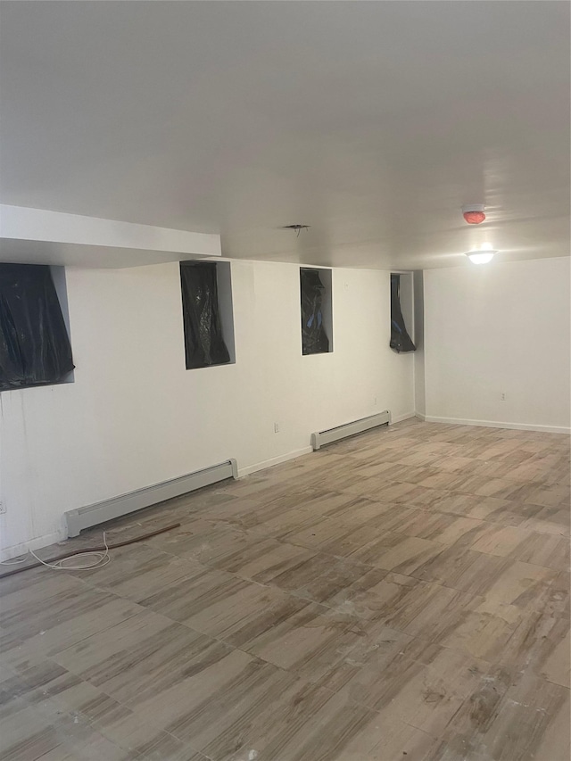 3418 Irwin Ave, Bronx, NY 10463 - finished below grade area featuring a baseboard heating unit, wood finished floors, and baseboards