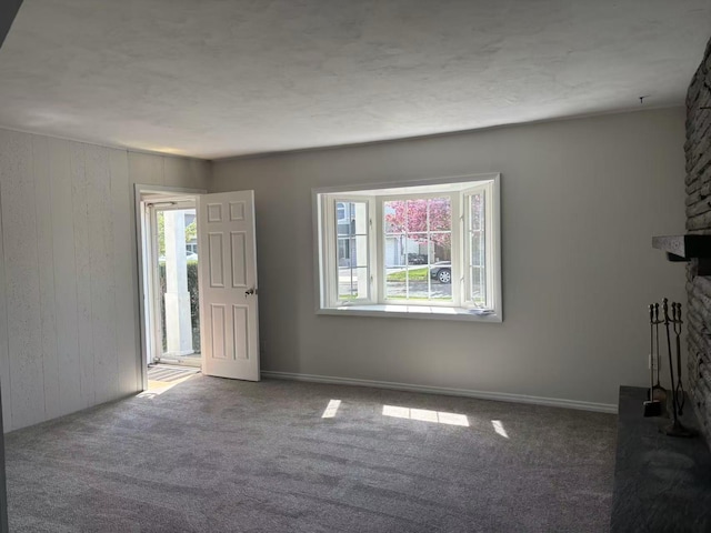 2333 Beech St, Wantagh, NY 11793 - unfurnished living room with plenty of natural light, a fireplace, carpet, and wood walls