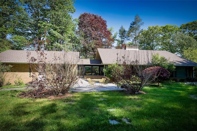 1 Ridge Rd, Tuxedo Park, NY 10987 - back of house featuring a patio area, a lawn, a chimney, and brick siding