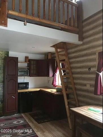 981 New Hague Rd, Call Listing Agent, NY 12836 - kitchen featuring wood finished floors, light countertops, black microwave, dark brown cabinets, and open shelves