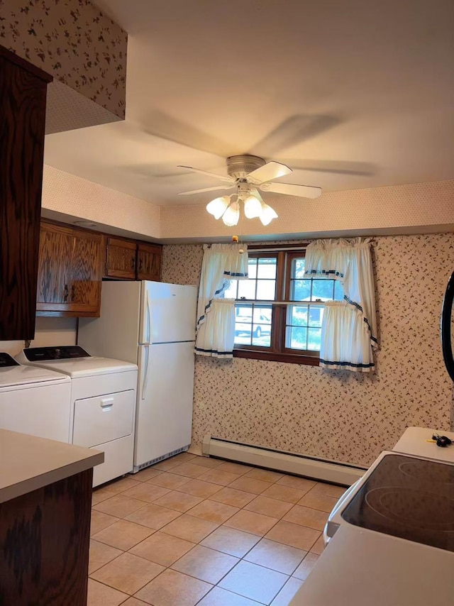 2090 Post St, East Meadow, NY 11554 - kitchen with wallpapered walls, a baseboard radiator, a ceiling fan, separate washer and dryer, and white appliances