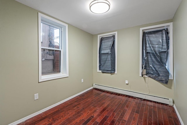 107-30 156th St, Jamaica, NY 11433 - empty room featuring a baseboard heating unit, baseboards, and dark wood-style flooring