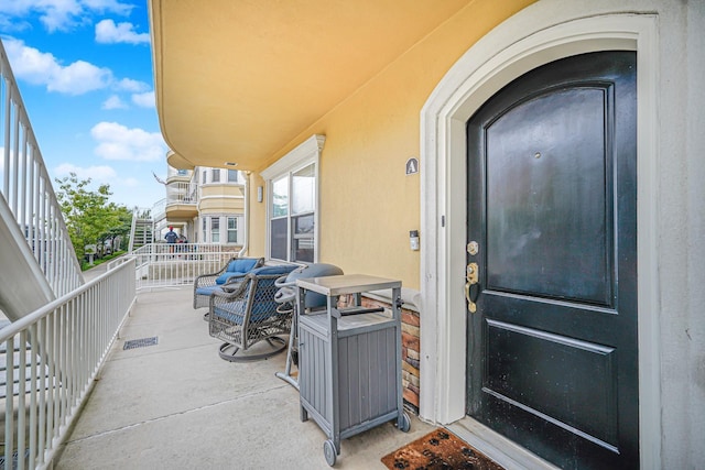 entrance to property with stucco siding and a balcony