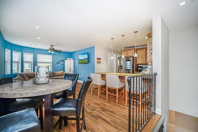 dining area with light wood-type flooring, recessed lighting, a ceiling fan, and baseboards
