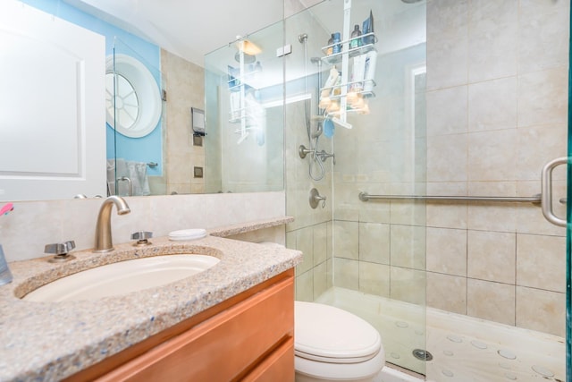 full bathroom with a shower stall, vanity, and toilet