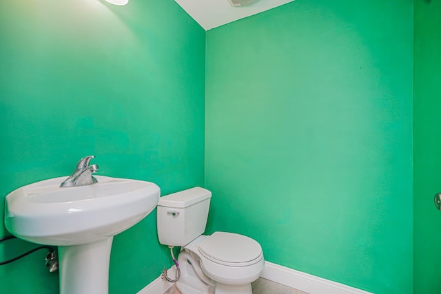 bathroom featuring baseboards and toilet
