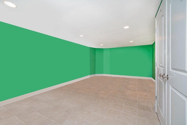 spare room with recessed lighting and baseboards