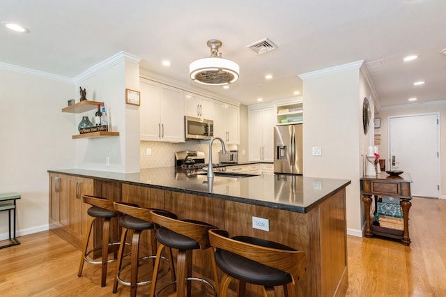 260 W Broadway Unit 2B, Long Beach, NY 11561 - kitchen featuring stainless steel appliances, open shelves, a peninsula, crown molding, and light wood finished floors