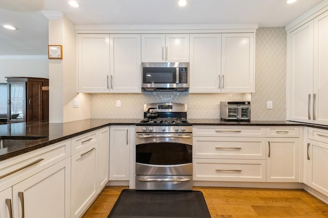 260 W Broadway Unit 2B, Long Beach, NY 11561 - kitchen featuring stainless steel appliances, dark stone counters, tasteful backsplash, white cabinetry, and recessed lighting