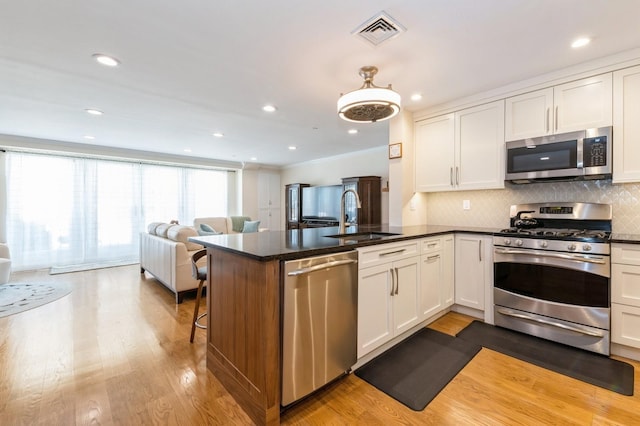 260 W Broadway Unit 2B, Long Beach, NY 11561 - kitchen with appliances with stainless steel finishes, a sink, a peninsula, backsplash, and open floor plan