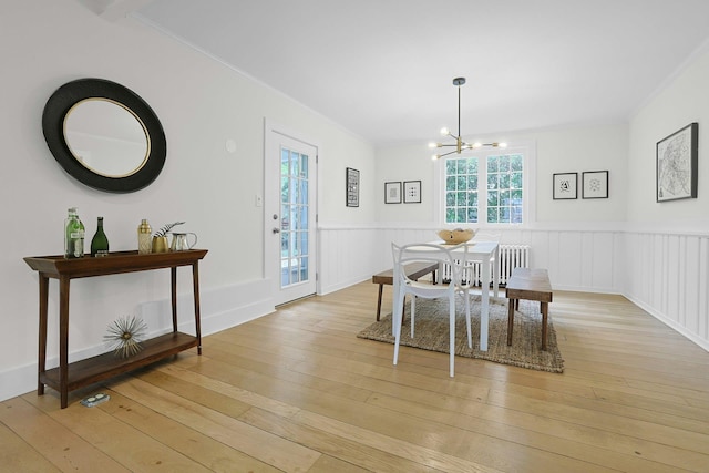 92 Glenwood Ave, New Rochelle, NY 10801 - dining area featuring light wood-style floors, a chandelier, ornamental molding, and a wainscoted wall
