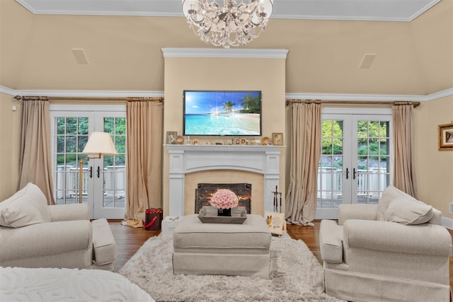 7 Ridgeview Cir, Armonk, NY 10504 - living room featuring french doors, dark wood-style flooring, a chandelier, ornamental molding, and a lit fireplace