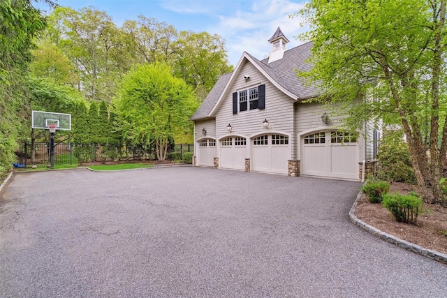 7 Ridgeview Cir, Armonk, NY 10504 - view of side of property featuring driveway, a shingled roof, fence, and an attached garage