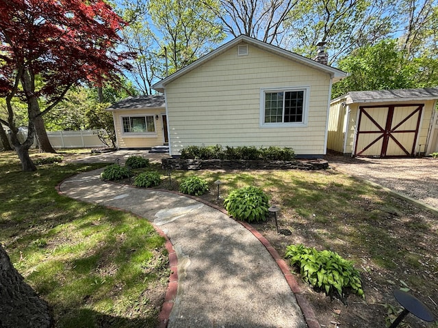 212 Longfellow Dr, Mastic Beach, NY 11951 - view of front of home with a shed, fence, and an outbuilding