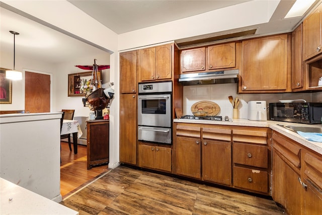 71-34 Kissena Blvd, Flushing, NY 11367 - kitchen with under cabinet range hood, stainless steel oven, a warming drawer, black microwave, and brown cabinetry