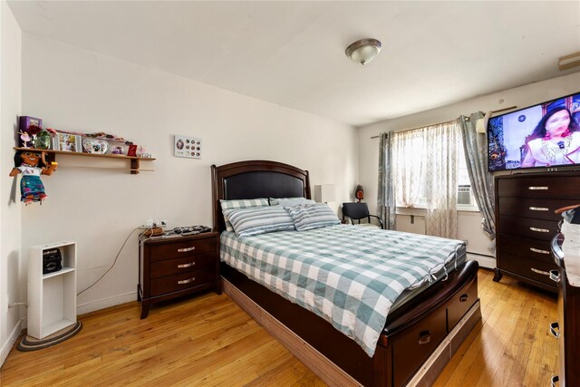 71-34 Kissena Blvd, Flushing, NY 11367 - bedroom featuring baseboard heating, light wood-type flooring, and baseboards
